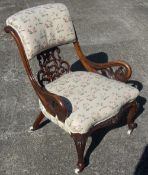 A Victorian walnut upholstered open armchair