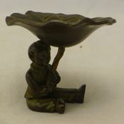 A bronze figure of a boy and a lily