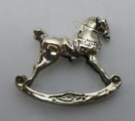 A miniature silver model of a rocking horse