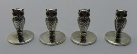 A set of four owl menu holders