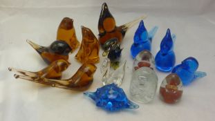 A collection of glass birds and paperweights