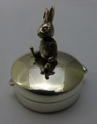 A silver pill box mounted with a rabbit