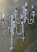 A pair of white painted plaster three branch wall lights