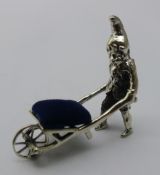 A silver gnome and wheelbarrow pin cushion