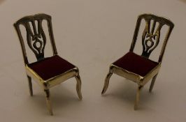 A pair of miniature silver chairs