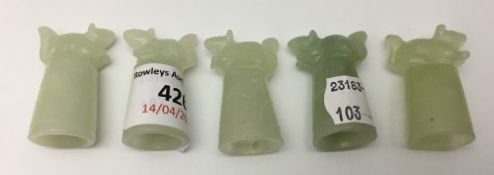 A set of five jade thimbles each surmounted with an animal