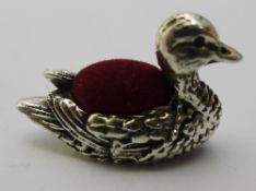 A silver pin cushion in the form of a duck