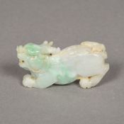 A Chinese carved pale green jade temple lion 8 cm long.