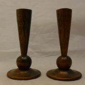 A pair of turned oak candlesticks