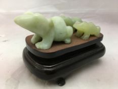 Three jade frogs on a common wooden base