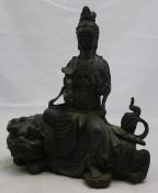 A bronze figure of Guanyin seating on a dog-of-fo