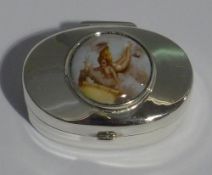 A silver oval pill box depicting a girl