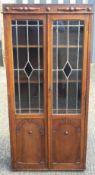 An early 20th century lead glazed oak bookcase