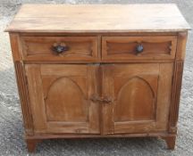 A Continental pine two door and two drawer side cupboard