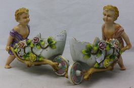 A pair of porcelain cherub carts