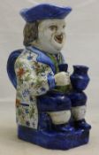A Delft Toby Jug seated and holding a jug and a glass