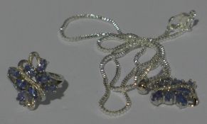 A suite of matching 925 silver tanzanite and white stone set pendant with chain and ring