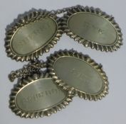 A set of four silver wine decanter labels