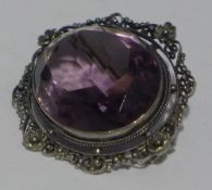 A silver and amethyst brooch