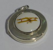 A silver locket depicting a plane