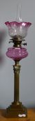 A Victorian cranberry oil lamp with Corinthian column