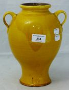 A yellow glazed twin handled pottery vase, marked for Liberty,