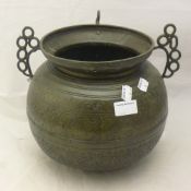 An Eastern antique bronze cauldron with incised scroll decoration and pierced handles