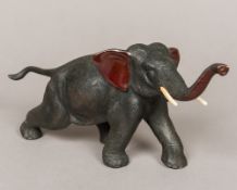 A Japanese Meiji period patinated bronze elephant Modelled walking on all fours with ivory tusks