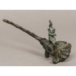 A Chinese cast metal opium pipe The bowl worked with a grotesque mask. 22 cm long.
