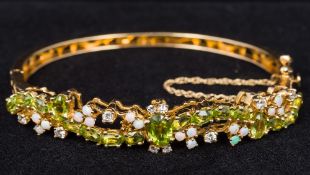 A 14 ct gold peridot, opal and diamond bracelet Of hinged bangle form,