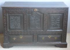 An 18th century oak mule chest The hinged rectangular top above the carved three panel front with