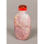 A Chinese carved hardstone snuff bottle Decorated with a fish amongst lilies. 6.75 cm high.