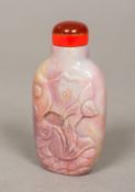 A Chinese carved hardstone snuff bottle Decorated with a fish amongst lilies. 6.75 cm high.