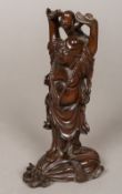 A Chinese finely carved wooden model of Buddha Modelled holding aloft a small child,