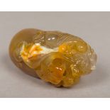 A carved agate pebble Decorated with a dog-of-fo with a carved ball inside his mouth. 9.5 cm long.