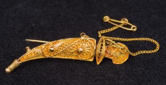 An 18 ct gold filigree brooch Formed as a Jambiya, stamped 750. 5 cm wide.