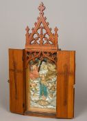 A cased travelling religious icon The hinged folding pierced Gothic arched wooden case enclosing