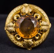 A Victorian unmarked gold citrine brooch Of pierced floral target form. 3.75 cm diameter.