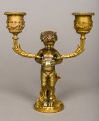 A 19th century Continental gilt bronze twin branch candelabrum Worked with the figure of an infant