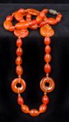 A 1920s Chinese carved carnelian necklace Set with beads, roundels and two carved monkeys.