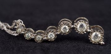 A 9 ct white gold diamond set pendant Set with seven graduated illusion set diamonds,