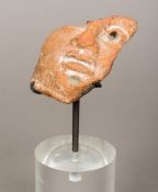 A Roman pottery fragment Modelled as part of a male bust, mounted on a later perspex display plinth.