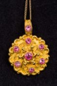An unmarked gold, probably 14/15 ct pink stone set pendant Of pierced and cast scrolling form,