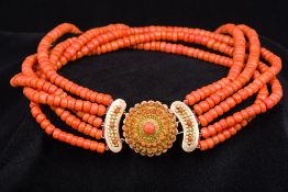 An 18 ct gold mounted coral bead necklace Of five strand form with coral set domed clasp.