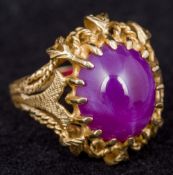 An unmarked gold star ruby set ring The claw set cabochon stone above pierced shoulders. 2.