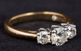 An 18 ct gold and platinum three stone diamond ring The central stone approximately 0.5 carat.