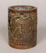 A Chinese bronze brush pot Cast in the round with figures in various pursuits amongst a pagoda and