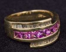 A 14K gold diamond ring Centred with a row of pink stones flanked by two rows of diamonds.