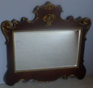 An 18th century style gilt heightened mahogany wall glass The shaped frame decorated with