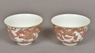 A pair of Chinese porcelain bowls Each painted with dragons chasing flaming pearls in iron red,